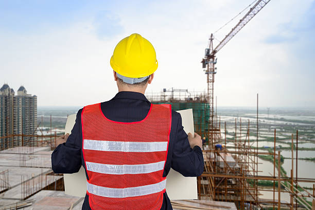 istock Young architects looking at blueprint in front of construction s 496265097