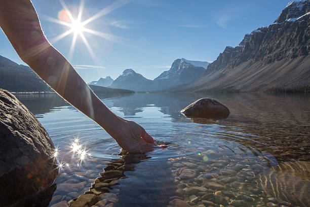 istock Human hand cupped to catch the fresh water from lake 496265234