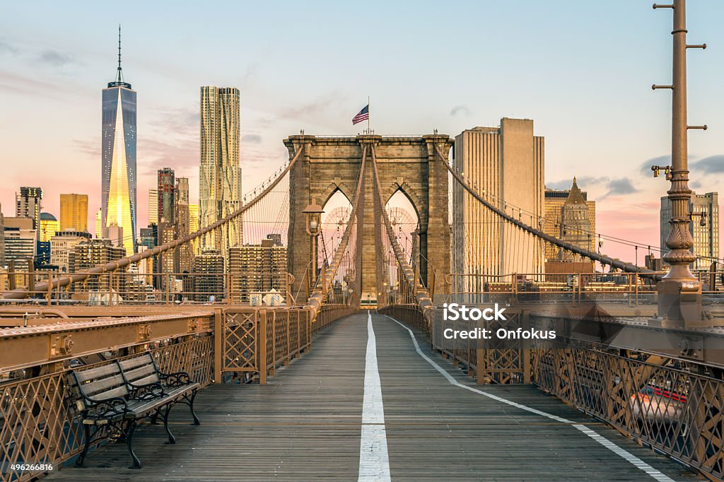 Brooklyn Bridge and Lower Manhattan at Sunrise, New York City The Famous Brooklyn Bridge at Sunrise, New York City, USA. The sun is rising over Brooklyn on this beautiful day of Autumn New York City Stock Photo
