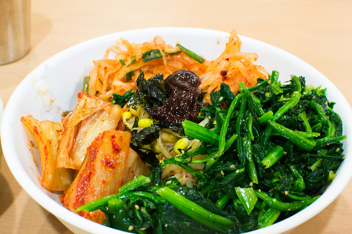 This traditional Korean Dish is Bibimbap. It features spinach and of course rice and Kimchi