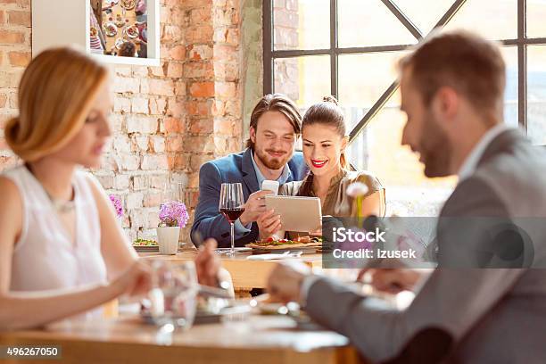 Elegant Couple Using A Digital Tablet In The Restaurant Stock Photo - Download Image Now