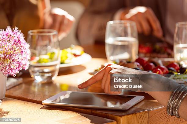 Woman Using A Digital Tablet In The Restaurant Stock Photo - Download Image Now - 2015, Adult, Bar - Drink Establishment