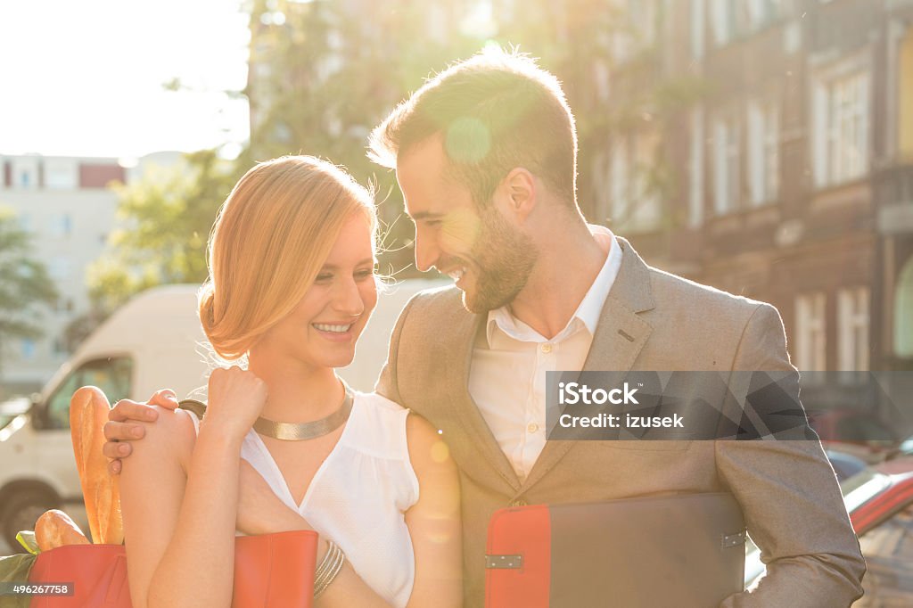 Affectionate couple talking on the street Happy couple standing on the street in the city at sunset, embracing and talking. 2015 Stock Photo