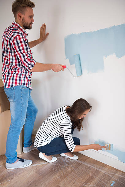 istock Cheerful couple painting their room blue 496268412