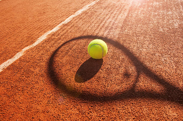 bola de tênis e raquete na argila tribunal sombra - tennis tennis racket racket tennis ball imagens e fotografias de stock