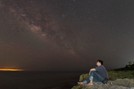 Asian man looking at galaxy in the sky