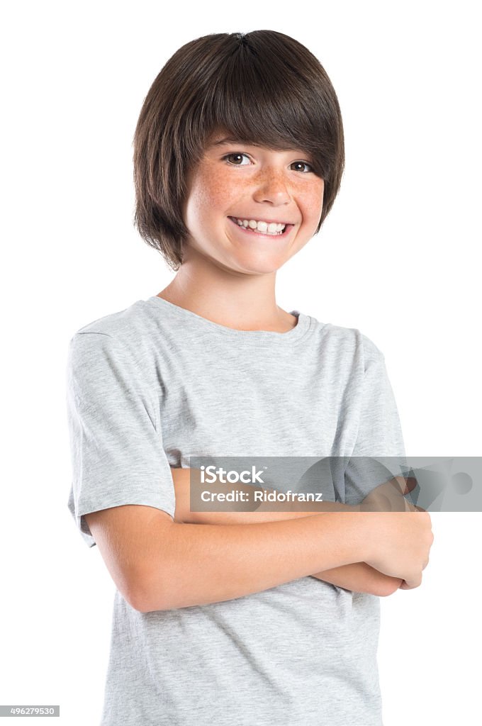 Cute boy smiling Portrait of a little boy standing with armcrossed. Studio portrait of happy male kid looking at camera. Smiling cute child with grey t-shirt laughing isolated on white background. Child Stock Photo