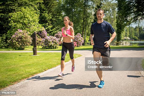 Couple Jogging In Park Stock Photo - Download Image Now - 2015, 30-34 Years, 30-39 Years