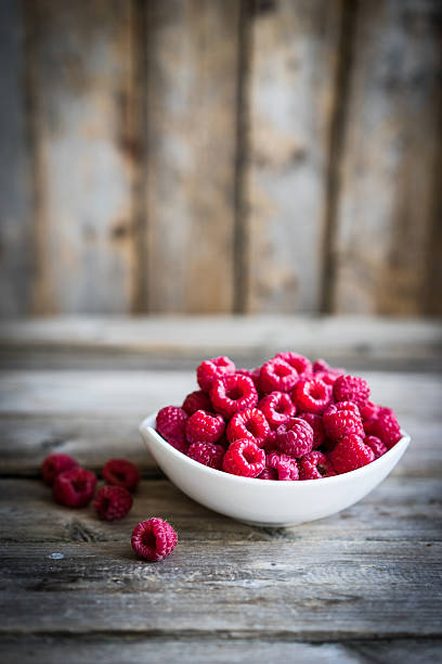 istock Fresh raspberries on rustic wooden background 496288058