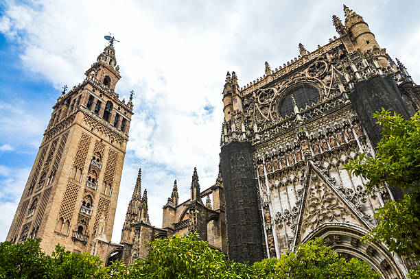 La Giralda & Seville Cathedral Exterior Seville, Spain - August 12, 2015: The exterior of the Giralda and the Seville Cathedral as seen from the plaza in front. The photo was taken during a warm summer day and contains no people. image created 21st century blue architecture wide angle lens stock pictures, royalty-free photos & images