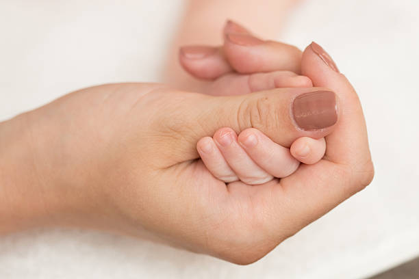 istock Baby's hand gripping adult finger 496303921