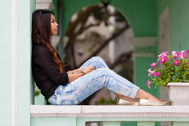 Asian woman sitting on veranda in Macau, China