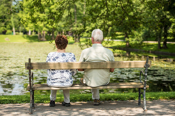 istock Senior couple sitting in park, rear view 496308384