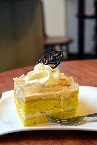 Slice of pear cream cake on a plate with fork