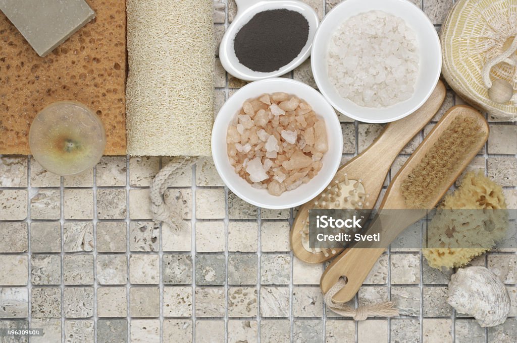 Bathroom accessories Set of bathroom accessory on stone tile: soaps, bath salt, clay, sponges, loofa. Top view point. Domestic Bathroom Stock Photo