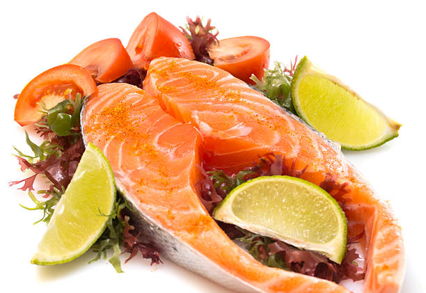 istock Salmon fillet with vegetables isolated on white background 496310385