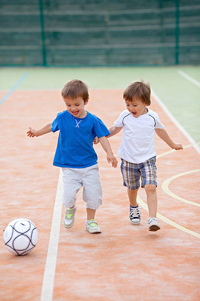 zwei kleine junge spielen fußball - playing field goalie soccer player little boys stock-fotos und bilder
