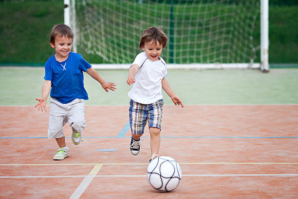 zwei kleine junge spielen fußball - playing field goalie soccer player little boys stock-fotos und bilder