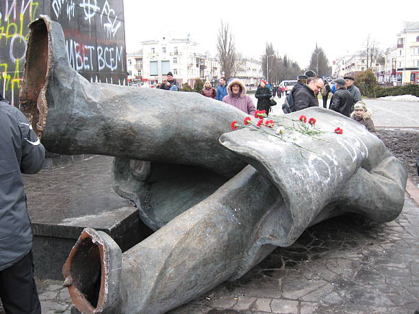 Chernihiv, Ukraine - February 23, 2014: people near the thrown big bronze monument to Lenin the leader of world proletariat in Chernihiv. 