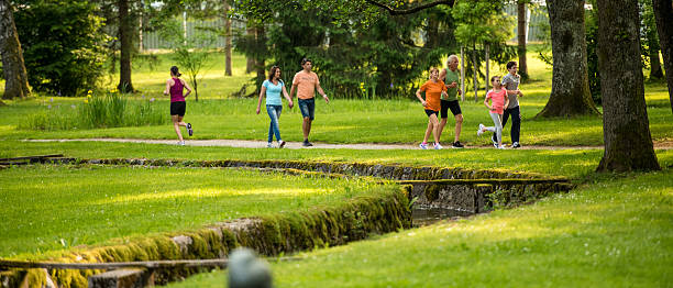 человек, бег трусцой в парке - walking exercising relaxation exercise group of people стоковые фото и изображения