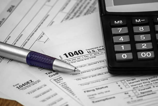 istock US tax form 1040 with pen and calculator 496316528