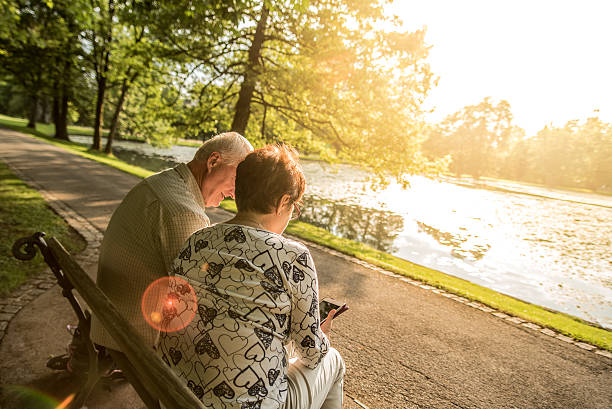istock Senior couple sitting in park, rear view 496317694