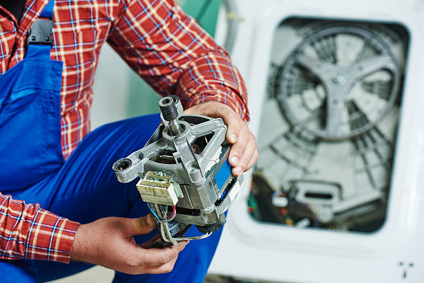 replacing engine of washing machine Washing machine repair. Repairer hands with electric engine motor in front of damaged unit  washing machine photos stock pictures, royalty-free photos & images