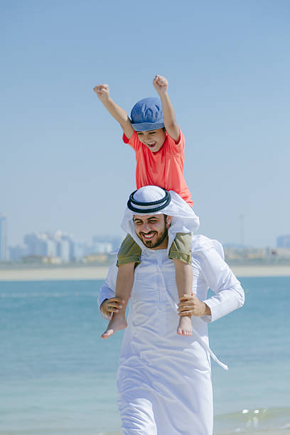 istock Arab father and son having fun at beach 496322340