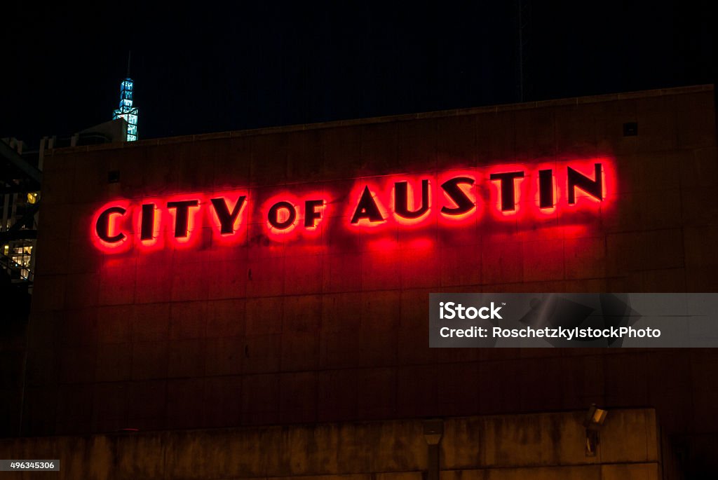 City of Austin Glowing Red City of Austin Glowing Red from the old Power Plant in the downtown district of the central texas capital city of Austin , Texas . At night this long exposure of the City of Austin sign lights up a red glow of bright color in the city sky  Austin - Texas Stock Photo