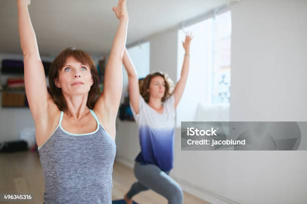 Two Women Practicing Yoga Forms At Class Stock Photo - Download Image Now - 2015, Active Lifestyle, Adult