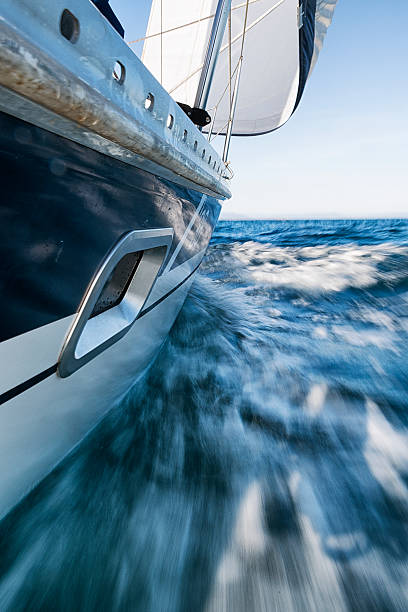 Sailing Boat Leaning, Low Wiewpoint, Motion Blurred A low viewpoint of a sailboat moving at 7 knots. Motion blurred. fast boat stock pictures, royalty-free photos & images