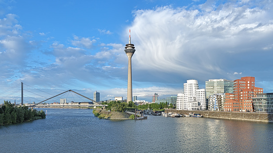 Media Harbor in Dusseldorf with Rheinturm TV tower on the background of the cloud front, Germany