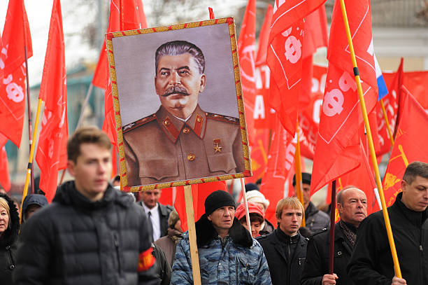 partido comunista reunião. de estaline retrato, vermelho bandeiras em mãos - vladimir lenin imagens e fotografias de stock