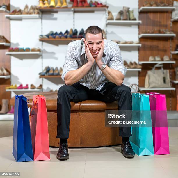 Hombre Está En Una Tienda De Zapatos Foto de stock y más banco de imágenes de 30-34 años - 30-34 años, 30-39 años, Aburrimiento
