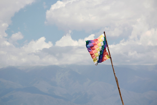 A row of colorful flags fluttering in the wind in the sun