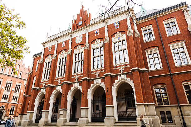 Krakow, Poland - April 24, 2014: Front facade of Collegium Novum - one of the oldest academic buildings of Jagiellonian University in Krakow Poland. There are some people visible walking nearby.