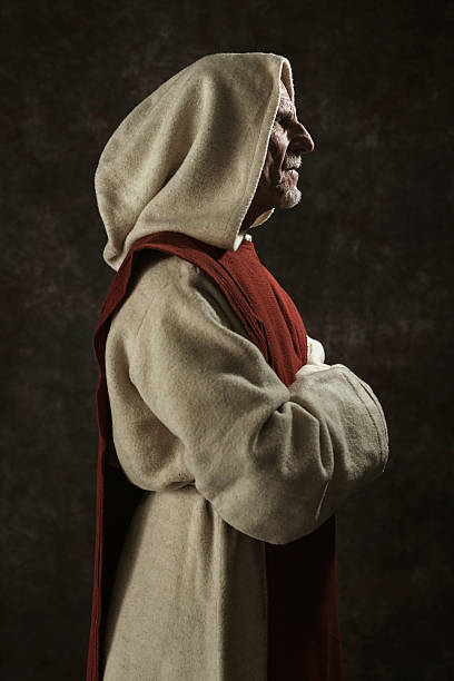 istock Side view portrait of monk. Studio shot against dark wall. 496350250