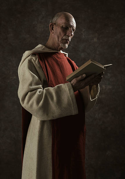 istock Official portrait of monastic reading book. Against dark wall. 496350580