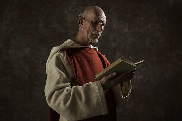 istock Official portrait of monastic reading book. Against dark wall. 496350604