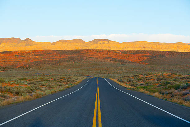 Desert Highway A quiet stretch of highway in Utah, USA. Popular with road bicyclists, motorcycle riders and motorists.  single yellow line sunlight usa utah stock pictures, royalty-free photos & images