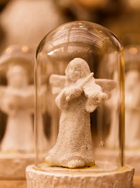 Figurines of angels under a bell jar.