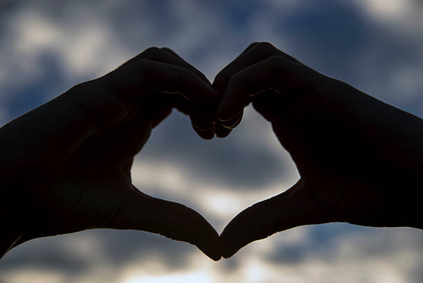 istock Hand heart shape silhouette made against the sun 496353106