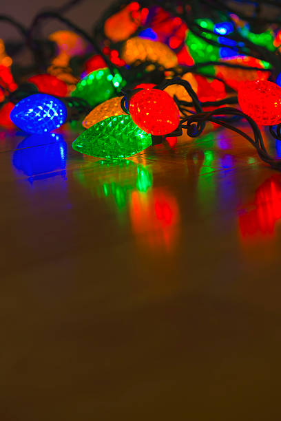 istock Multi-Colored Christmas lights on hardwood floor 496354184