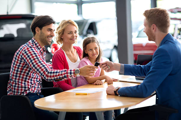 car dealer selling new vehicle to young family car dealer selling new car to young family with child girl car salesperson photos stock pictures, royalty-free photos & images