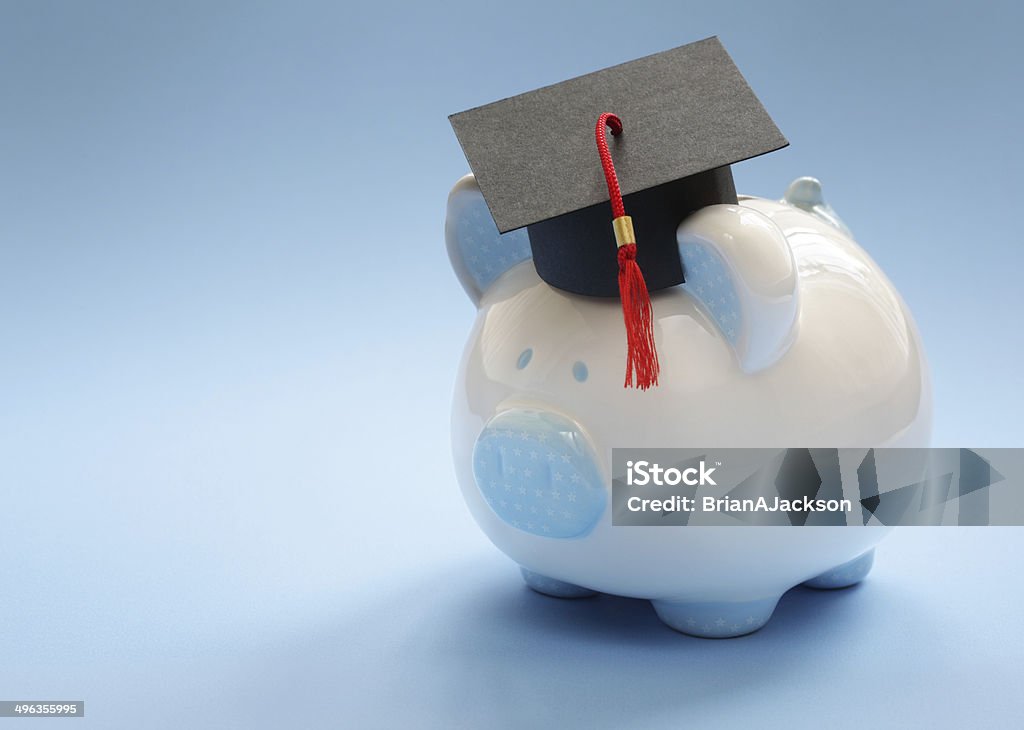 Saving for an education Piggy bank with a graduation mortar board cap concept for the cost of a college education University Student Stock Photo