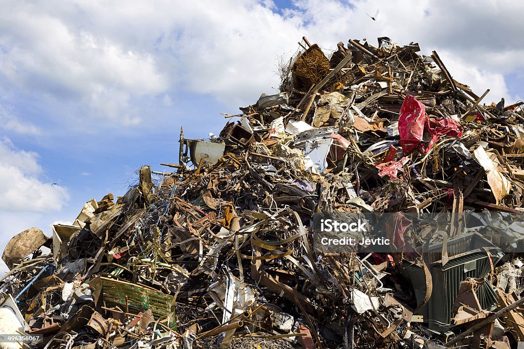 Metal waste Pile of metal waste for recycling, blue sky and white clouds in background Abandoned Stock Photo