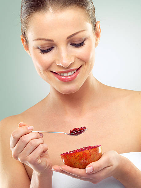 istock Beautiful young woman eating a grapefruit with a teaspoon 496356160