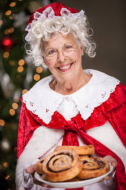 Ms. Claus With Plate of Cinnamon Rolls stock photo