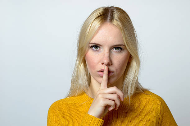 istock Pretty Woman Showing Shushing Gesture at Camera 496380264