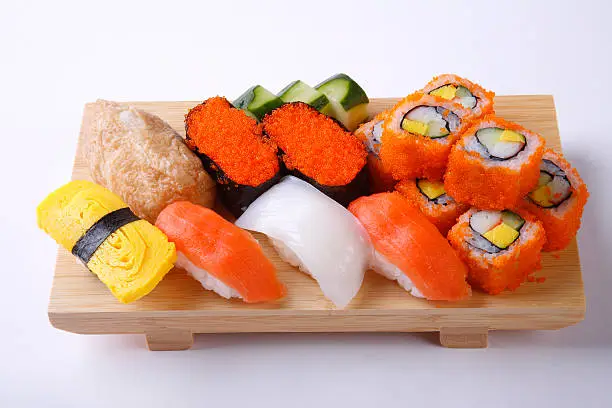Photo of Mixed sushi set on wooden tray isolated on white background